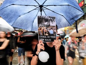 Protesters walk along a street during a rally in Hong Kong on August 18, 2019, in the latest opposition to a planned extradition law that has since morphed into a wider call for democratic rights in the semi-autonomous city. - Hong Kong democracy activists gathered August 18 for a major rally to show the city's leaders their protest movement still attracts wide public support despite mounting violence and increasingly stark warnings from Beijing.
