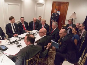 This image released by the White House Press Secretary, Sean Spicer, on Twitter on April 07, 2017 shows President Donald Trump receiving a briefing on the Syria military strike from the National Security team via secure video teleconference on April 06, 2017 at the Mar a Lago estate in West Palm Beach, Florida. President Trump, staring directly ahead, is surrounded at the table by (clockwise from left) Deputy Chief of Staff Joe Hagin, son-in-law Jared Kushner, Treasury Secretary Steven Mnuchin, Commerce Secretary Wilbur Ross, Secretary of State Rex Tillerson, National Security Adviser H.R. McMaster and Chief of Staff Reince Priebus. Sitting a row back from the table are Sean Spicer, chief strategist Stephen Bannon, senior adviser Stephen Miller, national security aide Michael Anton, Deputy National Security Adviser Dina Powell, and National Economic Council Director Gary Cohn. A military aide guards the door. (WHITE HOUSE/Getty Images)