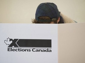 CP-Web.  A woman marks her ballot behind a privacy barrier in the riding of Vaudreuil-Soulanges, west of Montreal, on election day on October 19, 2015.