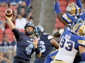 Argonauts quarterback McLeod Bethel-Thompson makes the pass under pressure during first-half action against the Winnipeg Blue Bombers on Thursday night in Toronto. The Argos rallied for their first win of the season.  (NATHAN DENETTE/THE CANADIAN PRESS)