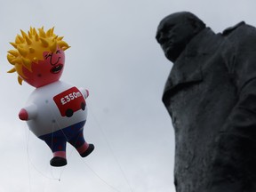 A giant inflatable blimp depicting Boris Johnson is flown near a statue of former British Prime Minister Winston Churchill opposite the Houses of Parliament, ahead of anti-Brexit "No to Boris, Yes to Europe" protest in London, July 20,2019. REUTERS/Simon Dawson