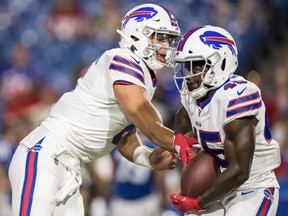 Bills quarterback Tyree Jackson (left) hands the ball off to running back Christian Wade for a touchdown carry during the fourth quarter of a preseason game against the Colts at New Era Field in Orchard Park, N.Y., on Thursday, Aug. 8, 2019.