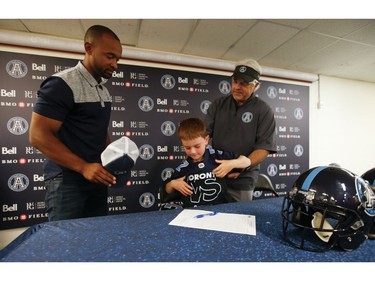 Darius Raso, 7, of Kleinburg, Ont. signed a one-day contract with the Toronto Argonauts and GM Jim Popp (R)  and got his players jersey from two-time Argos Grey Cup champ Matt Black. He was diagnosed and battling acute lymphocytic leukemia for the past year and was out on the field with the Argos. He will also be at the Labour Day Classic in Hamilton. on Thursday August 29, 2019. Jack Boland/Toronto Sun/Postmedia Network