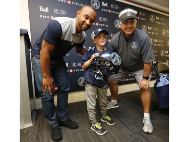 Darius Raso, 7, of Kleinburg, Ont. signed a one-day contract with the Toronto Argonauts and GM Jim Popp (R)  and posed for pictures two-time Argos Grey Cup champ Matt Black. He was diagnosed and battling acute lymphocytic leukemia for the past year and was out on the field with the Argos. He will also be at the Labour Day Classic in Hamilton. on Thursday August 29, 2019. Jack Boland/Toronto Sun/Postmedia Network