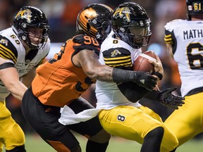 Davon Coleman sacks Tiger-Cats quarterback Jeremiah Masoli during a game last season. The Argonauts have acquired the defensive lineman from the B.C. Lions. (Darryl Dyck/The Canadian Press)