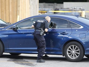 Toronto Police officers investigate after two men were wounded by gunfire and a Hyundai Sonata was riddled with bullet holes at a lowrise apartment complex on Rochefort  in Flemingdon Park on Wednesday, Aug. 7, 2019.