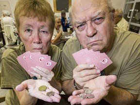 Betty Bennett and Christopher Cronk hold up a notice from the City of Toronto, letting them know they can only play their afternoon euchre game at Scarborough Village Community Centre for 25 cents not their usual pot of $1.25 on Thursday, Aug. 8, 2019.