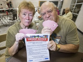 Betty Bennett and Christopher Cronk hold up a notice from the City of Toronto, letting them know they can only play their afternoon euchre game at Scarborough Village Community Centre for 25 cents not their usual pot of $1.25 on Thursday, Aug. 8, 2019. (Craig Robertson/Toronto Sun/Postmedia Network)