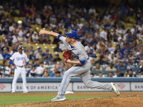Blue Jays closer Ken Giles delivers a pitch during the eighth inning against the Dodgers on Wednesday night at Dodger Stadium.  Giles left for the paternity list yesterday, leading the way to Canadian reliever Jordan Romano’s callup. (USA TODAY SPORTS PHOTO)