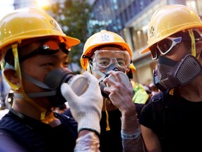 Protesters protect themselves with helmets and masks during a demonstration to demand Hong Kong's leaders step down and withdraw an extradition bill, in Hong Kong, China, on June 21, 2019.