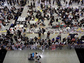 Anti-Extradition bill protesters distribute leaflets to passengers  during a mass demonstration at the Hong Kong international airport, in Hong Kong, China, Aug. 13, 2019.