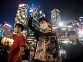 Secondary school students wave their phones in the air during an anti-government student rally in Hong Kong, China, on Thursday, Aug. 22, 2019.