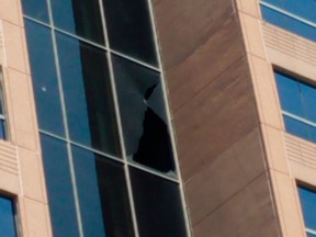 A large hole can be seen where bullets shattered a window of a building in the 1700 block of NE Loop 410 that houses administrative executive offices of ICE's Enforcement and Removal Operations Tuesday, Aug. 13, 2019 in San Antonio, Texas.