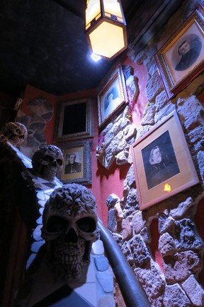 Skulls on the handrail and old photos along staircase lead to the second landing inside the Haunted Castle suite, which opened in December 2017. (Ian Robertson)
