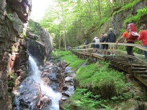 Visitors walk along a pathway overlooking the Flume Gorge in Franconia Notch State Park, N.H. (Ian Robertson)