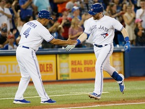 Toronto Blue Jays right fielder Billy McKinney celebrates with third base coach Luis Rivera (left) after hitting a home run during the sixth inning against the Texas Rangers at Rogers Centre.