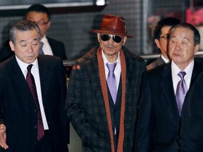 Kenichi Shinoda, centre, the boss of Japan's largest Yakuza gang, the Yamaguchi-gumi, at Tokyo's Shinagawa station.