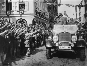 German-speaking schoolchildren welcome Adolf Hitler in a street decorated with swastikas in the Sudetenland, Czechoslovakia. The territory was occupied by Germany after the Munich agreement of 1938. (Central Press/Getty Images)
