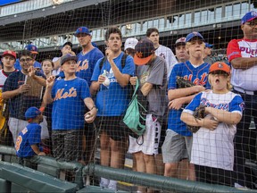 New York Mets fans lean up against the newly installed protective netting that spans to the fouls poles on each end of the field prior to a game against the Chicago White Sox at Guaranteed Rate Field. (Patrick Gorski-USA TODAY Sports)