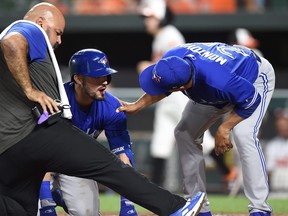 Randal Grichuk of the Toronto Blue Jays is checked by manager Charlie Montoyo #25 and assistant athletic trainer Jose Ministral after fouling a pitch into his face in the ninth inning against the Baltimore Orioles at Oriole Park at Camden Yards on Aug. 1, 2019 in Baltimore, Md. (GREG FIUME/Getty Images)