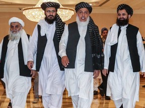 Mohammad Nabi Omari (second from left), a Taliban member formerly held by the U.S. at Guantanamo Bay and reportedly released in 2014 in a prisoner exchange, Taliban negotiator Abbas Stanikzai (second from right), and former Taliban intelligence deputy Mawlawi Abdul Haq Wasiq (right) walk with another Taliban member during the second day of the Intra Afghan Dialogue talks in Doha, Qatar, on July 8, 2019.