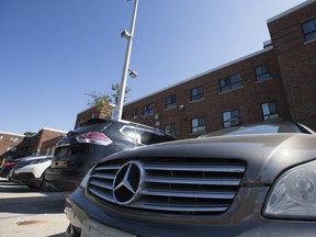 A line of luxury cars — all with resident parking permits — in the parking lot of a Toronto Community Housing complex on Aug. 14 2019