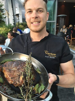 Executive chef Garett Blundell of The Victor in Vancouver’s Parq resort proudly shows off a magnificent 28-ounce porterhouse steak tableside before slicing. (Kevin Hann)
