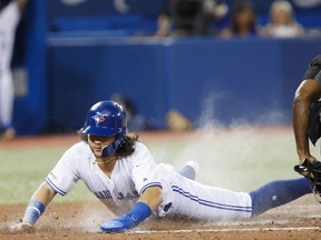 Bo Bichette of the Toronto Blue Jays slides into home to score off a Vladimir Guerrero Jr. #27 sacrifice fly during the fifth inning of their MLB game against the Boston Red Sox at Rogers Centre on September 11, 2019 in Toronto, Canada.
