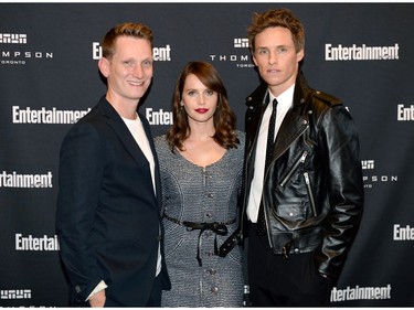 Tom Harper, Felicity Jones and Eddie Redmayne attend Entertainment Weekly's Must List Party at the Toronto International Film Festival 2019 at the Thompson Hotel on Sept. 7, 2019 in Toronto.
