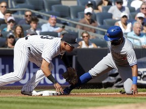 NEW YORK, NEW YORK - SEPTEMBER 21:   Richard Urena #7 of the Toronto Blue Jays is tagged out trying to advance to third base during the third inning by Gio Urshela #29 of the New York Yankees at Yankee Stadium on September 21, 2019 in New York City.