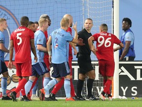 New York City FC and Toronto FC players talk to referee Chris Penso during the second half of Wednesday's game at Yankee Stadium. (USA TODAY SPORTS)