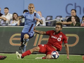Toronto FC's Nick DeLeon (right) fights for control of the ball with New York City FC's Alexandru Mitrita during Wednesday's game. (AP PHOTO)