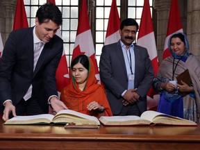 Nobel Peace laureate Malala Yousafzai signs a guest book with Canadian Prime Minister Justin Trudeau. An ardent advocate for women and girls' education, she bcame only the sixth person to receive honorary Canadian citizenship. (AFP photo)