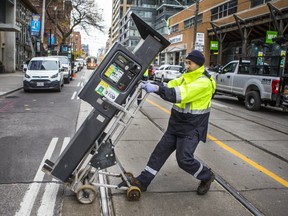 A worker is pictured removing a parking ticket dispenser prior to the implementation of the King St. pilot project in the fall of 2017. (Ernest Doroszuk, Toronto Sun)