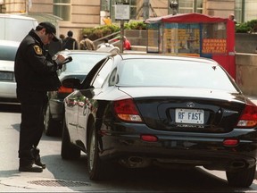 This Toronto Sun file photo shows a Toronto bylaw officer issuing a ticket for idling.
