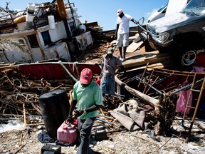 People recover items from a beached boat after Hurricane Dorian September 5, 2019, in Marsh Harbor, Great Abaco.  (Photo by Brendan Smialowski / AFP)