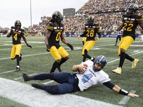Argonauts quarterback McLeod Bethel-Thompson slides out of bounds while pursued by 
a collection of Tiger-Cats during the Labour Day Classic in Hamilton. (THE CANADIAN PRESS)
