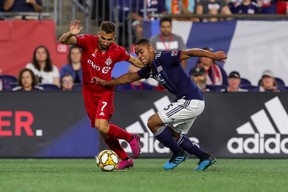Toronto FC midfielder Nicolas Benezet (left) fights for possession against New England Revolution midfielder Brandon Bye during a game on Aug. 31. (Paul Rutherford/USA TODAY Sports)