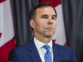 Federal Liberal incumbent candidate Bill Morneau listens during an announcement by federal Liberal leader Justin Trudeau at a campaign event in Toronto on Sept. 20, 2019.