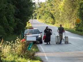 This file photo taken on Aug. 20, 2017 shows a cab dropping off a couple of asylum seekers at the U.S./Canada border near Champlain, N.Y.