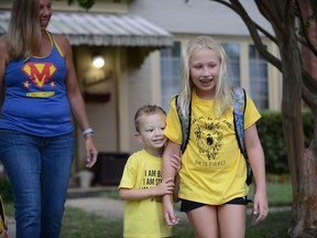 Whitaker Weinburger, his sister Lakeland and his mother, Erin Weinburger, leave their home in Alexandria, Virginia, to see more than 100 yellow cars lined up in the street and neighbours decorating their homes to celebrate Whitaker's fourth birthday on Wednesday, Sept. 11, 2019. (Photo for The Washington Post by Astrid Riecken)