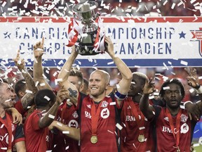 Toronto FC captain Michael Bradley lifts the Voyageurs Cup after the Reds defeated the Vancouver Whitecaps 5-2 to win 
the Canadian Championship final in Toronto last August. TFC is in Montreal tonight to begin defence of the title. (CP FILES)
