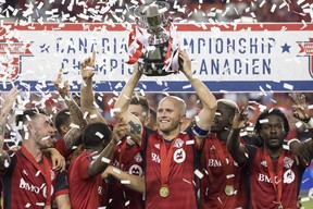 Toronto FC captain Michael Bradley lifts the Voyageurs Cup after the Reds defeated the Vancouver Whitecaps 5-2 to win 
the Canadian Championship final in Toronto last August. TFC is in Montreal tonight to begin defence of the title. (CP FILES)