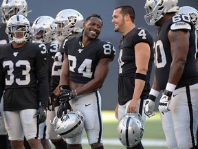 Oakland Raiders wide receiver Antonio Brown (84) and quarterback Derek Carr (4) hold their helmets before a game against the Green Bay Packers at Investors Group Field in Winnipeg. (Kirby Lee-USA TODAY Sports)