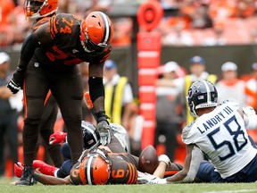 Chris Hubbard of the Cleveland Browns helps Baker Mayfield up after Mayfield was pressured by Harold Landry III of the Tennessee Titans and sacked by Cameron Wake during the fourth quarter at FirstEnergy Stadium on Sept. 8, 2019 in Cleveland, Ohio.