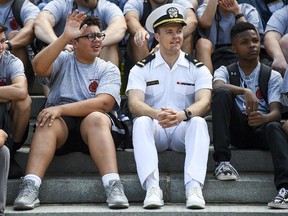 Ensign Christian Montgomery sits with International Burn Camp member Josh Gray, 14, of Waldorf, Md., during a tour of the Naval Academy in Annapolis, Md. MUST
