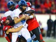 Toronto Argonauts quarterback McLeod Bethel-Thompson is sacked by Nate Holley and Cordarro Law of the Calgary Stampeders during CFL football in Calgary on Thursday, July 18, 2019. Al Charest/Postmedia