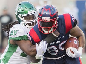 Montreal Alouettes' Spencer Moore, right, is tackled by Saskatchewan Roughriders' Solomon Elimimian during CFL action in Montreal, Friday, August 9, 2019. (THE CANADIAN PRESS/Graham Hughes)