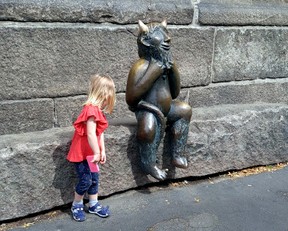 A young girl seems tempted by a devil-like statue outside a church in Lubeck. (DAVE POLLARD/Toronto Sun)