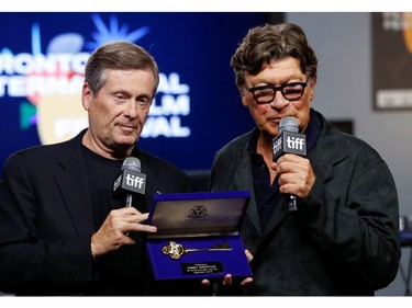 Musician Robbie Robertson receives the key to the city from Toronto Mayor John Tory during a news conference for the biopic "Once Were Brothers: Robbie Robertson and The Band" at the Toronto International Film Festival (TIFF) in Toronto, Sept. 5, 2019.